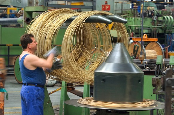 Ein Mitarbeiter der Swissmetal in Dornach am 13. Juni 2005 mit frisch gepresstem Draht aus Kupferlegierung. Die Swissmetal entwickelt, produziert und vertreibt weltweit Spezialprodukte aus Kupfer und  ...