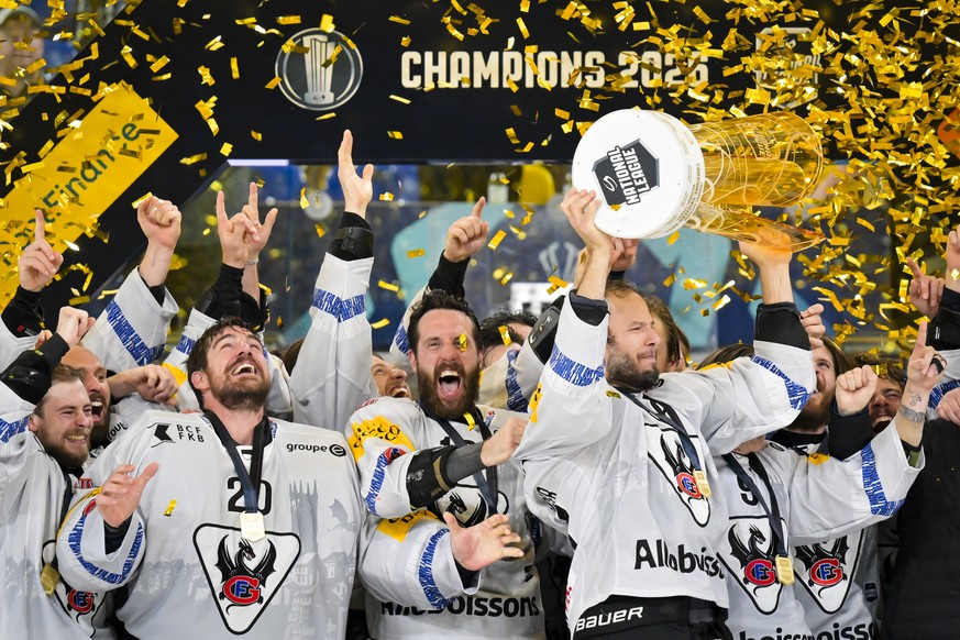 Die Fribourger Spieler mit Julien Sprunger feiern den Meistertitel mit dem Pokal nach ihrem Sieg gegen Davos in der Verlaengerung im siebten Eishockey Playoff Finalspiel der National League zwischen H ...