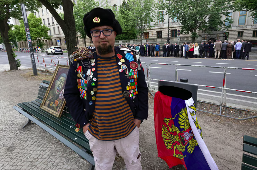 Der russische Aktivist Semyon Skrepetsky entsorgt in Berlin eine russische Fahne im Abfalleimer.