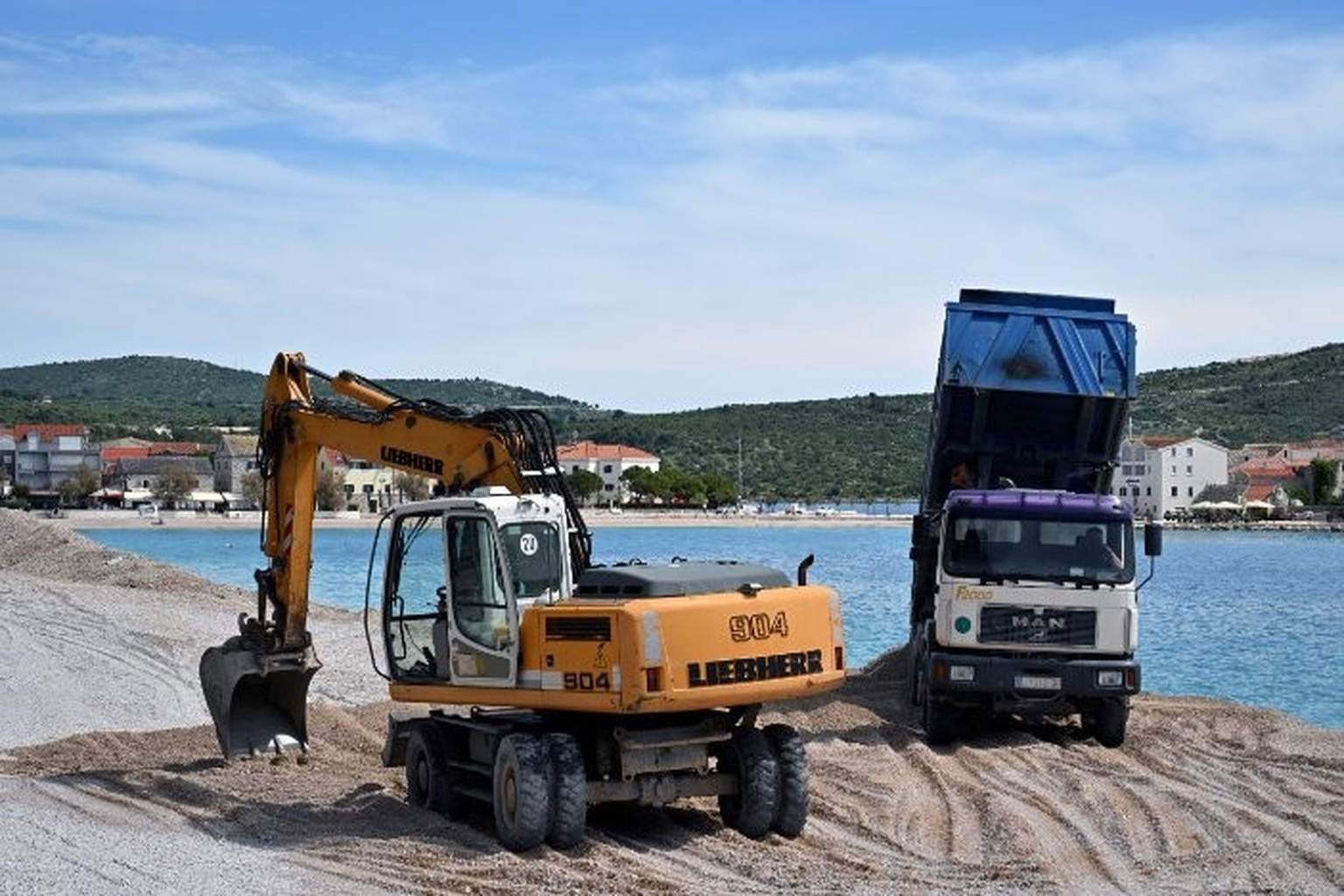 Cette photographie montre des machines lourdes en train de restaurer les plages artificielles de Primosten, une ville côtière de Croatie
