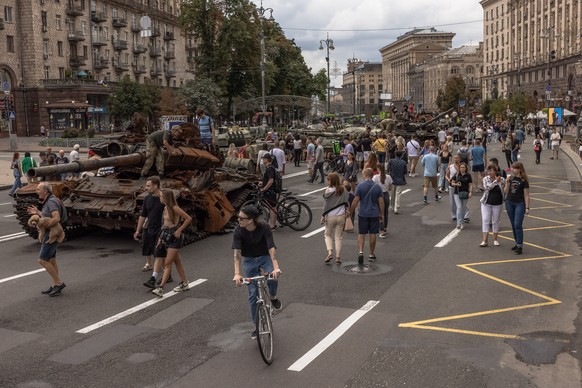 epa10130449 People look at Russian armoured military vehicles that were destroyed in fights with the Ukrainian army, displayed on Khreshchatyk street, in downtown Kyiv, ahead of the &#039;Independence ...