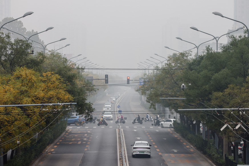 epa11696876 A general view of traffic on a road amid heavy fog in Beijing, China, 02 November 2024. China's National Meteorological Center issued a yellow warning for heavy fog on 02 November in  ...