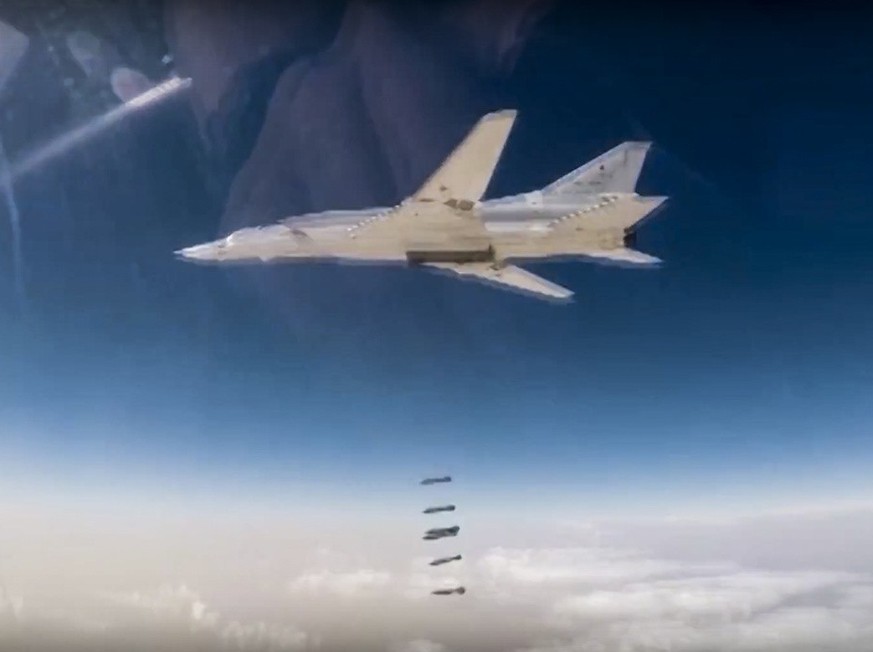 In this photo made from the footage taken from Russian Defense Ministry official web site on Friday, Nov. 3, 2017, a Russian Tu-22M bomber unloads bombs on IS targets near Abu-Kemal, Syria. The Russia ...