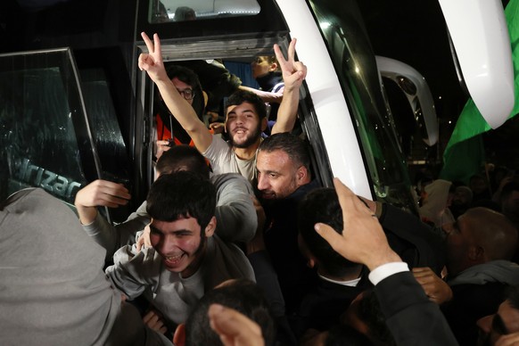 epa10998456 Palestinian prisoners freed from the Ofer Israeli military prison react as they get greeted by crowds awaiting their return in Beitonia, near Ramallah, West Bank, 28 November 2023. Israel  ...