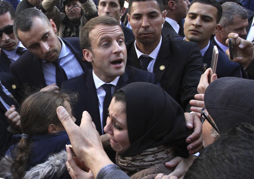 FILE- In this Dec.6, 2017 file photo, French President Emmanuel Macron meets residents in Algiers. Algeria has announced the immediate recall of its ambassador from Paris in a burst of fury over what  ...