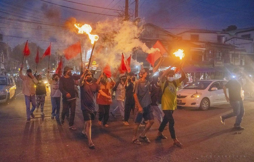 Pro-democracy protesters hold torches and flags during a flash mob rally to protest against Myanmar&#039;s military-government in Yangon, Myanmar on Sept.19, 2024. (Anti-Junta Alliance Yangon via AP)