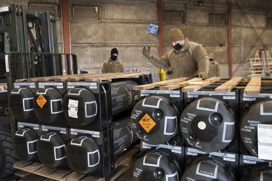 In this image provided by the U.S. Air Force, Airmen and civilians from the 436th Aerial Port Squadron palletize ammunition, weapons and other equipment bound for Ukraine during a foreign military sal ...