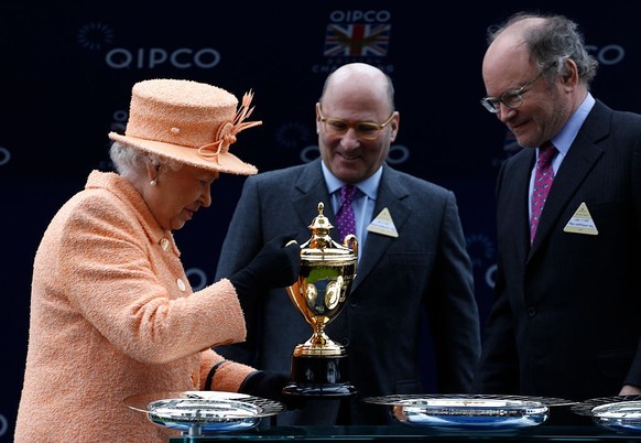 ASCOT, ENGLAND - OCTOBER 17: Queen Elizabeth II presents the trophy to owners Alain Wertheimer and Gerard Wertheimer, after their horse Solow won the Queen Elizabeth II Stakes Race run during the QIPC ...