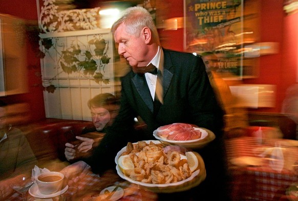 WEST HOLLYWOOD, CA  MARCH 7, 2009  Waiter Vladimir Bezak serving a table at Dan Tana's restaurant in West Hollywood, March 6, 2009. Customers Keat Bollenbach, cq, 25, LT, and brother Chris, 41, ...