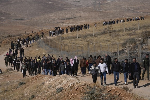 A line of people heads toward the infamous Saydnaya military prison, just north of Damascus, Syria, Monday, Dec. 9, 2024. Crowds are gathering to enter the prison, known as the &quot;human slaughterho ...