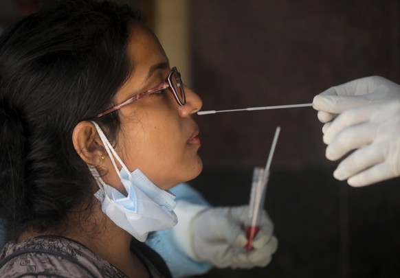 epa10051132 An Indian woman undergoes a Covid-19 swab test at a government hospital amid rising cases of Covid19 infection in Kolkata, Eastern India, 04 July 2022. According to the Indian Health Minis ...