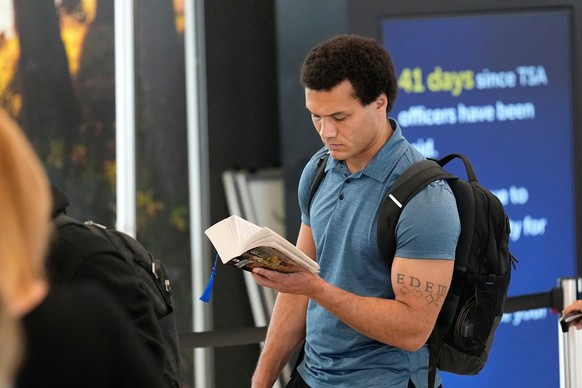 A traveler reads a book while waiting in long security checkpoint lines at George Bush Intercontinental Airport Friday, March 27, 2026, in Houston. (AP Photo/David J. Phillip)
Travel Delays