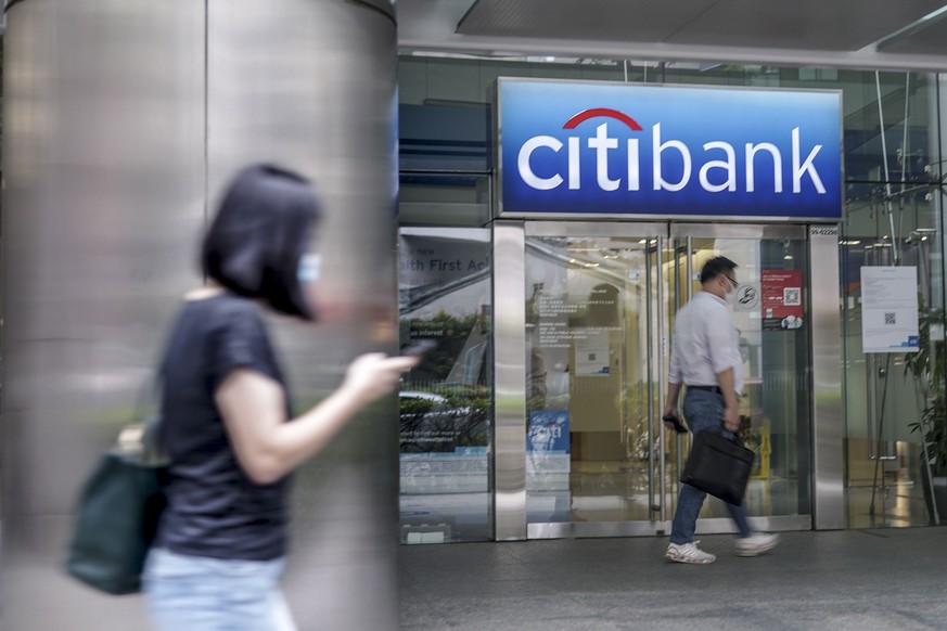 epa09139016 Pedestrians walk past a Citibank branch in Singapore, 16 April 2021. American bank Citigroup announced today that it will close its consumer banking operations in 13 markets across Asia, E ...