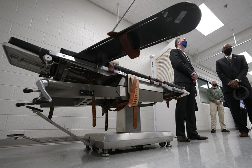 CORRECTS ID FROM VIRGINIA DIRECTOR OF CORRECTIONS HAROLD CLARKE TO GREENSVILLE CORRECTIONAL CENTER WARDEN LARRY EDMONDS - Gov. Ralph Northam, left, stands near a gurney with Greensville Correctional C ...