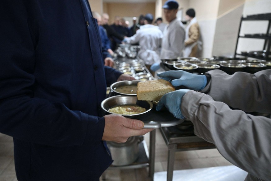 Des prisonniers de guerre russes prennent leur déjeuner dans un centre de détention pour prisonniers de guerre russes dans l'ouest de l'Ukraine, le 26 novembre 2025, alors que la Russie enva ...