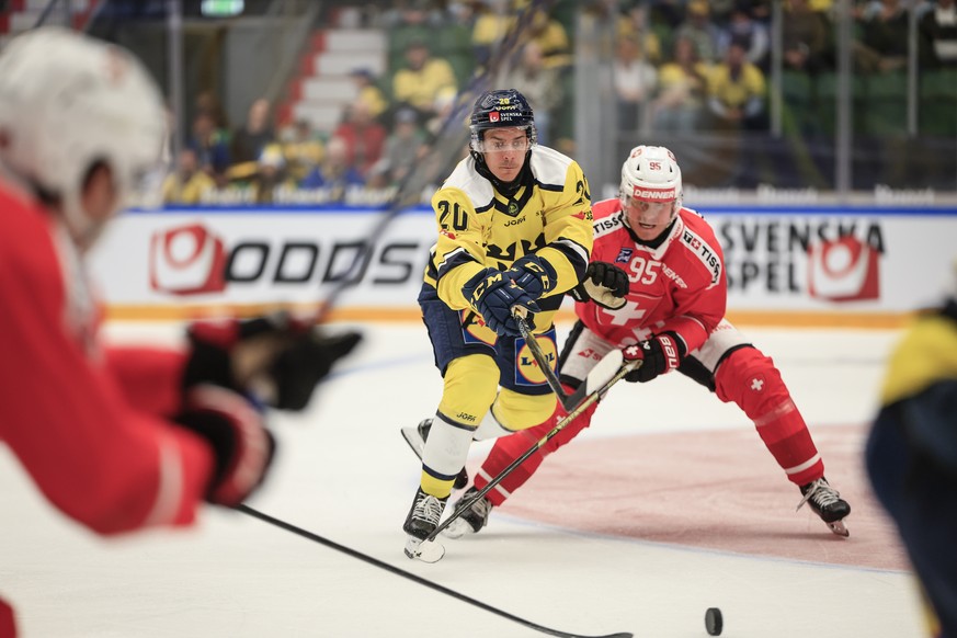 epa12943766 Sweden's Andre Petersson (L) and Switzerland's Tyler Moy in action during the Beijer Hockey Games match in the Euro Hockey Tour (EHT) between Sweden and Switzerland in Angelholm, ...