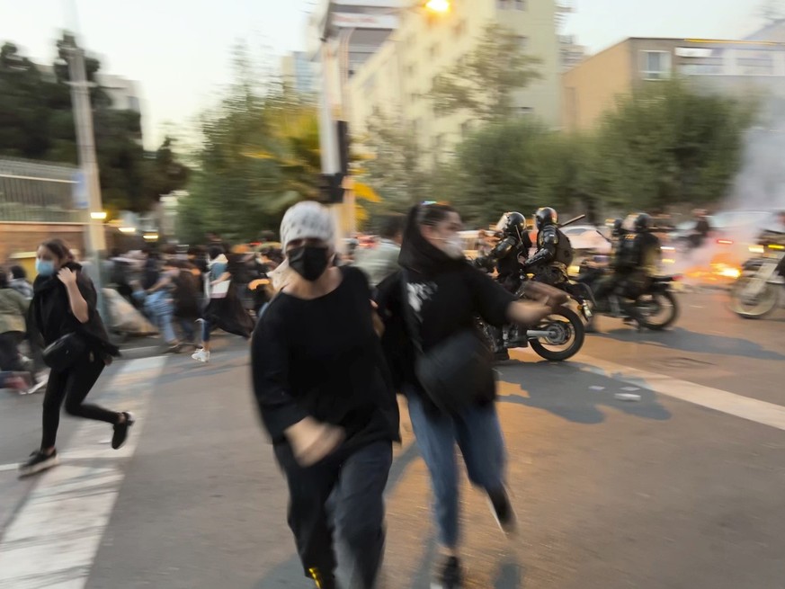 FILE - In this Monday, Sept. 19, 2022, photo taken by an individual not employed by the Associated Press and obtained by the AP outside Iran, women run away from anti-riot police during a protest of t ...