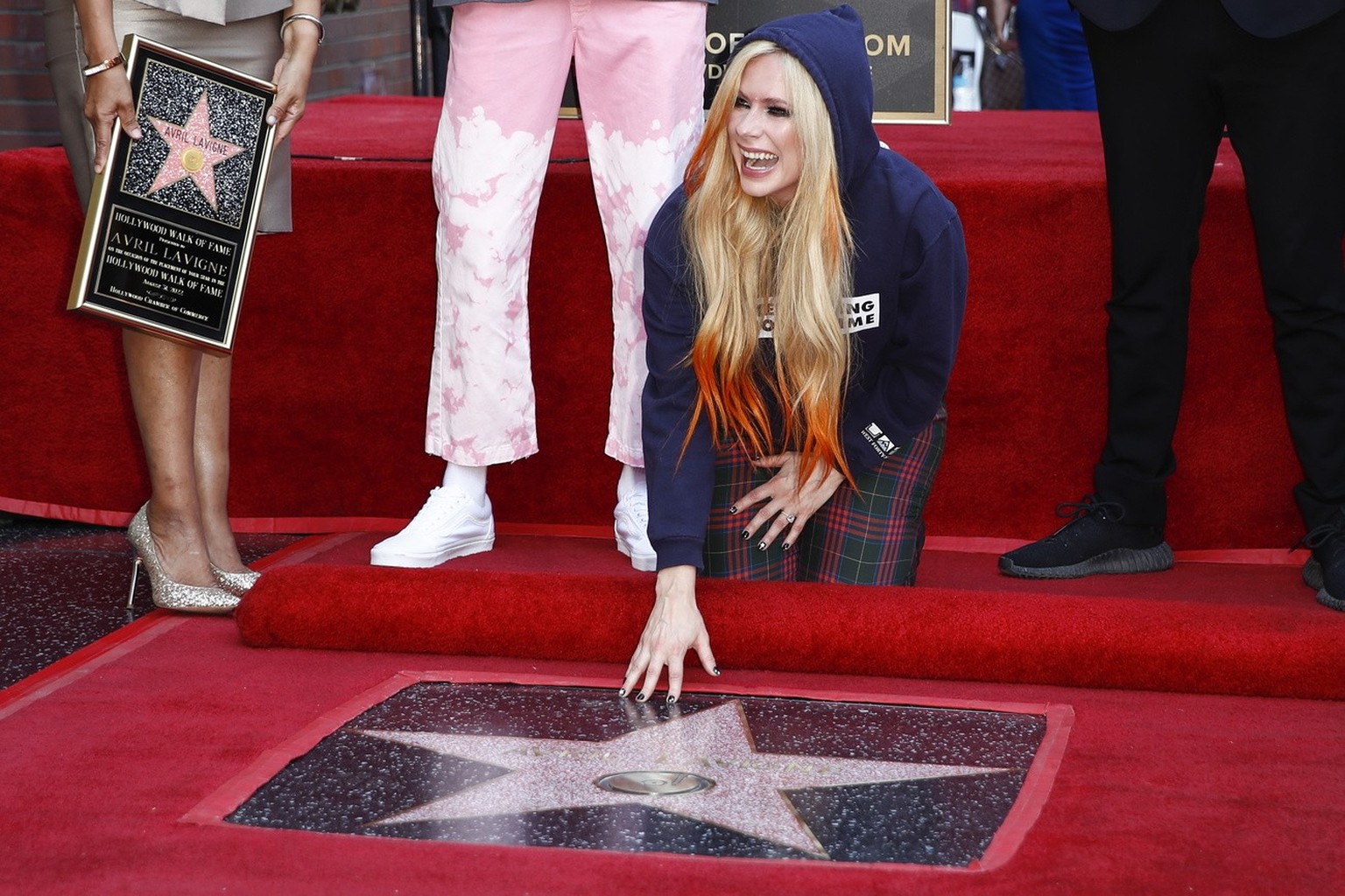 epa10150870 Canadian musician Avril Lavigne kneels by her newly unveiled Hollywood Walk of Fame star during a ceremony in her honor in Los Angeles, USA, 31 August 2022. EPA/CAROLINE BREHMAN