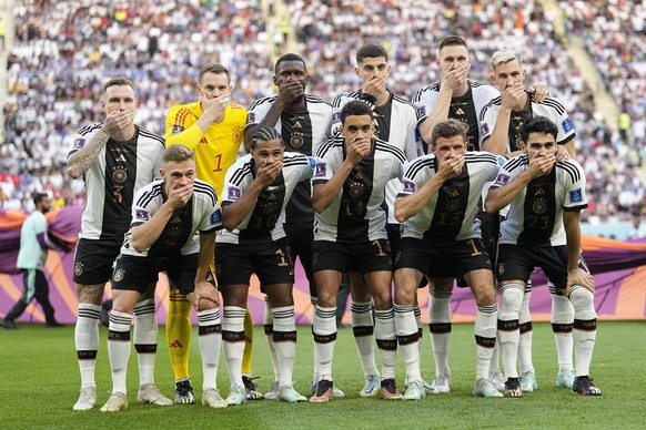 Players from Germany pose for the team photo as they cover their mouth during the World Cup group E soccer match between Germany and Japan, at the Khalifa International Stadium in Doha, Qatar, Wednesd ...
