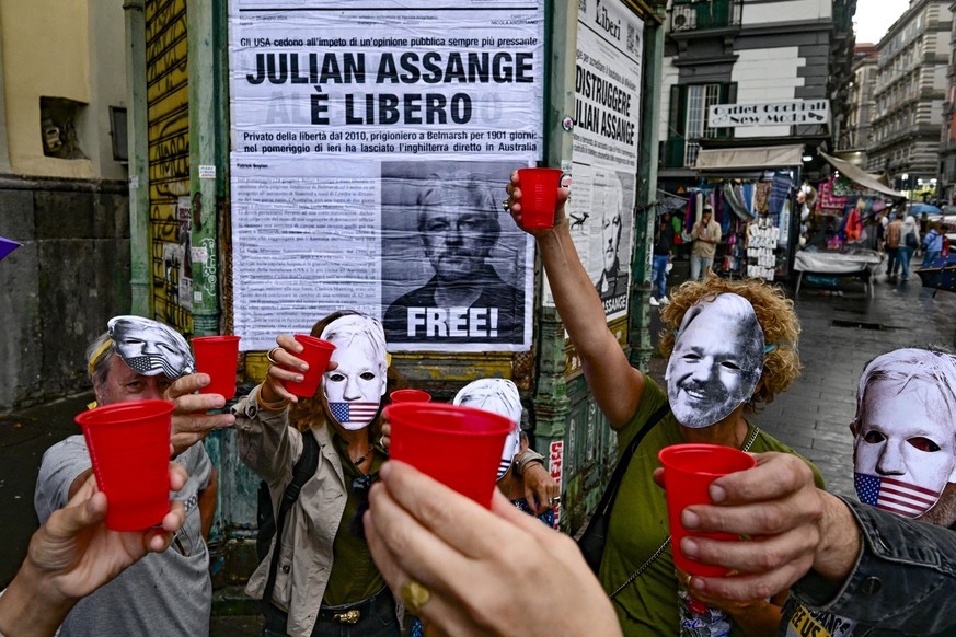 epa11437165 Activists of the FreeAssangeNapoli network put up a poster on an abandoned newsstand with the announcement of Julian Assange's release from prison and celebrate in Naples, Italy, 25 J ...