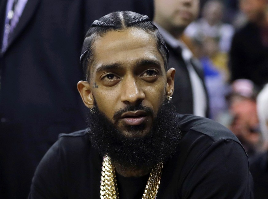 FILE - Rapper Nipsey Hussle attends an NBA basketball game between the Golden State Warriors and the Milwaukee Bucks in Oakland, Calif., March 29, 2018. Eric R. Holder Jr., who was convicted last year ...