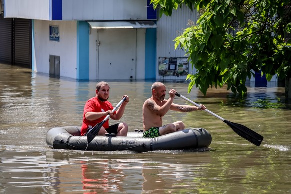 epa10677364 People move on a rubber boat along the flooded streets of Kherson, Ukraine, 07 June 2023. Ukraine has accused Russian forces of destroying a critical dam and hydroelectric power plant on t ...