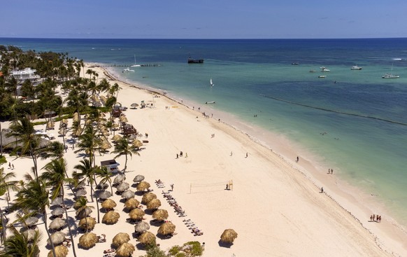 epa10591570 An aerial photograph shows people on a beach in Punta Cana, Dominican Republic, 25 April 2023. Forecasts indicate that in 2023 around 7.8 million tourists will arrive by air and 1.9 millio ...