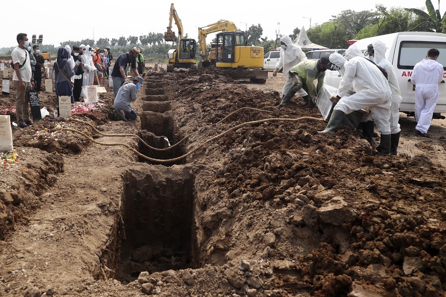 Workers prepare a row of new graves at the Rorotan Cemetery which is reserved for those who died of COVID-19, in Jakarta, Indonesia, Wednesday, July 7, 2021. Daily burials in the capital city have inc ...