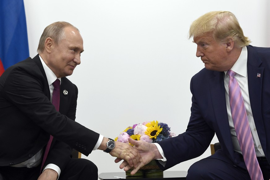 FILE - In this June 28, 2019, file photo, President Donald Trump, right, shakes hands with Russian President Vladimir Putin, left, during a bilateral meeting on the sidelines of the G-20 summit in Osa ...