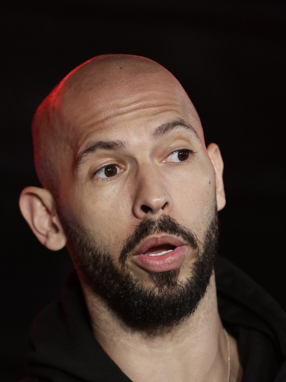 epa11980128 Former professional kickboxer and social media influencer Andrew Tate speaks with TV reporters after returning from a trip in the United States, in front of their property, in Bucharest, R ...