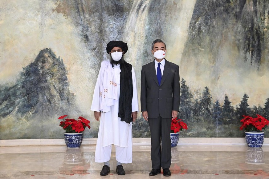 FILE - In this July 28, 2021, file photo released by China&#039;s Xinhua News Agency, Taliban co-founder Mullah Abdul Ghani Baradar, left, and Chinese Foreign Minister Wang Yi pose for a photo during  ...