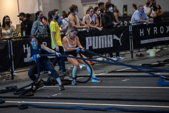 epa10314027 Competitors pull sleds loaded with weights during Hyrox, a global CrossFit race, at the Hong Kong Fitness and Wellness Expo a AsiaWorld Expo in Hong Kong, China, 19 November 2022. The expo ...