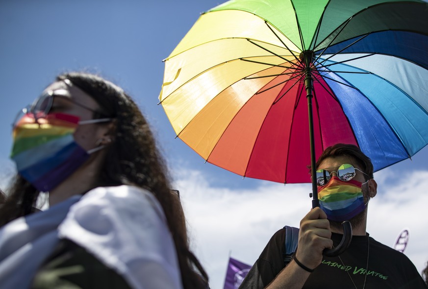 epa09285612 Members of the lesbian, gay, bisexual, transgender and queer (LGBTQ) community hold an umbrella with LGBTQI+ rainbow flag during a rally against Turkey&#039;s withdrawal from Istanbul Conv ...