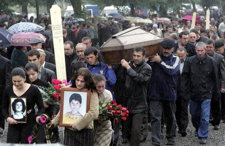 People carry the coffin with the body of Madina Sozanova, killed in a hostage taking crisis during the funerals in Beslan, North Ossetia, Monday 06 September 2004. 335 people died in a hostage taking  ...