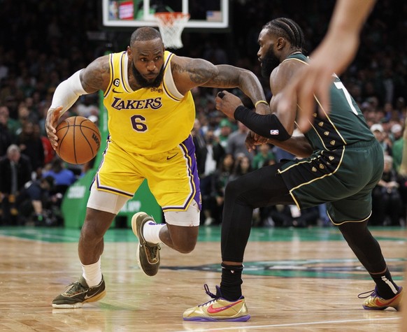 epa10437323 Los Angeles Lakers forward LeBron James (L) drives to the basket as Boston Celtics guard Jaylen Brown (R) defends during the Boston Celtics overtime win at the TD Garden in Boston, Massach ...