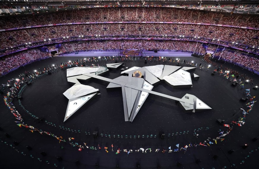 PARIS, FRANCE - AUGUST 11: (EDITORS NOTE: Image was captured using a robotic camera positioned above the field of play. A general view inside the stadium as flagbearers wave their national flags durin ...
