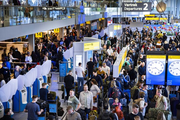 epa09906033 Travelers inside the departure hall of the Amsterdam Schiphol Airport, Netherlands, 24 April 2022. The airport warned of busy schedules throughout the day as several flights resumed after  ...