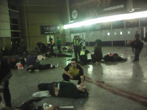 Helpers attend to people inside the Manchester Arena after a suspected suicide bomber detonated an explosive device at the end of an Ariana Grande concert, killing 22 people. (Photo by PA Images via G ...