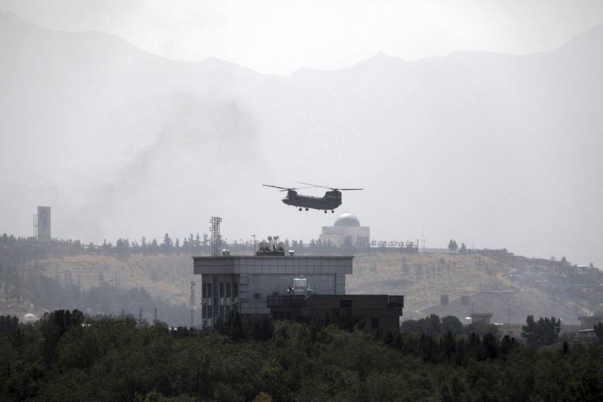 A U.S. Chinook helicopter flies over the U.S. Embassy in Kabul, Afghanistan, Sunday, Aug. 15, 2021. Helicopters are landing at the U.S. Embassy in Kabul as diplomatic vehicles leave the compound amid  ...