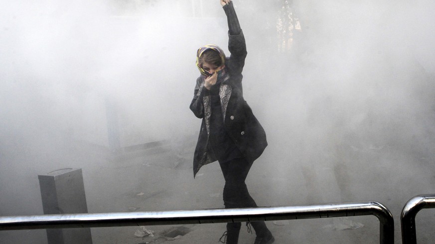 FILE - In this Saturday, Dec. 30, 2017 photo made by an individual not employed by the Associated Press and obtained by the AP outside Iran, a university student attends a protest inside Tehran Univer ...