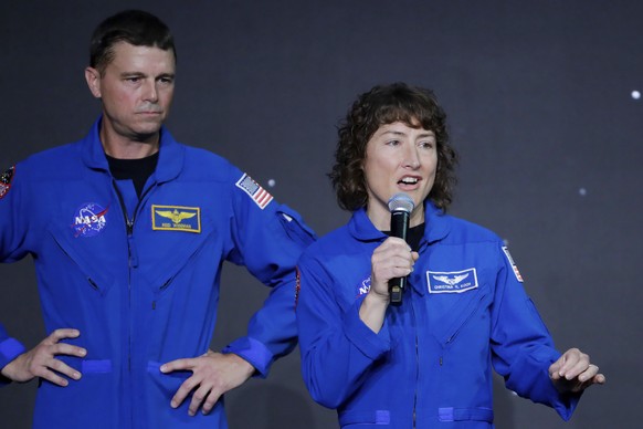 Mission commander Reid Wiseman, left, listens as mission specialist Christina Hammock Koch makes remarks during a NASA ceremony naming the four astronauts who will fly around the moon by the end of ne ...