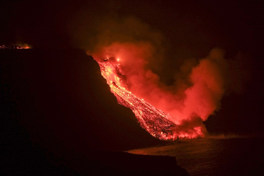 epa09494564 Lava flow from the Cumbre Vieja volcanic eruption in La Palma reaching the sea tonight in an area of cliffs next to Tazacortes coast in La Palma, Canary Islands, 28 September 2021. The Cum ...