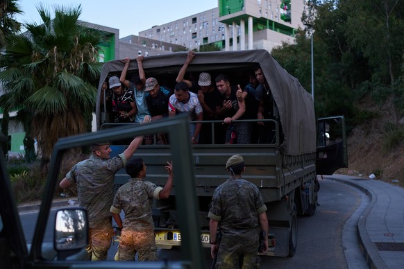 Migrants who crossed into Spain are escorted by Spanish soldiers towards the Spanish-Moroccan border for their return to Morocco from the Spanish enclave of Ceuta, Sunday, Aug. 2, 2026. (AP Photo/Bern ...
