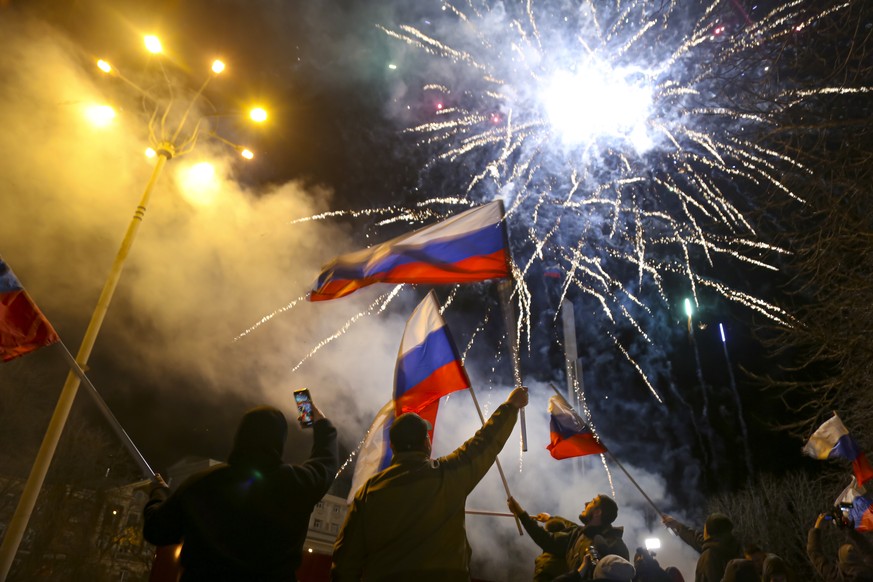 People wave Russian national flags celebrating the recognizing the independence in the center of Donetsk, the territory controlled by pro-Russian militants, eastern Ukraine, late Monday, Feb. 21, 2022 ...