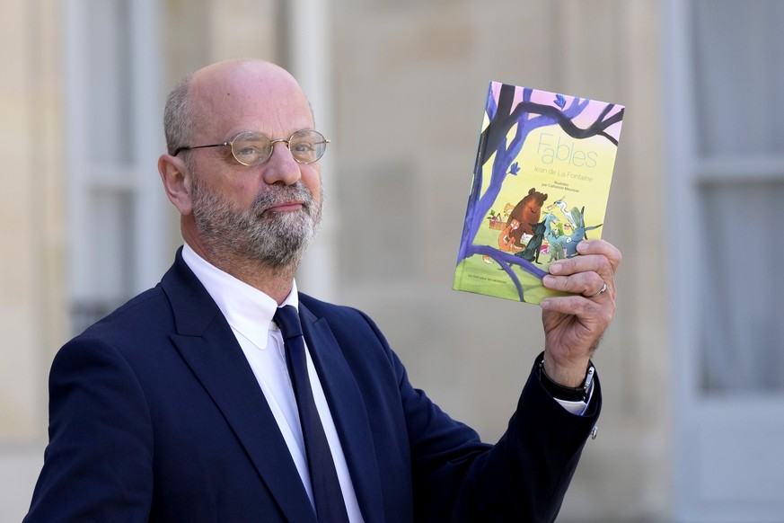 French Education, Youth and Sports Minister Jean-Michel Blanquer shows The Fables of Jean de la Fontaine book as he walks out after the weekly cabinet meeting, at the Elysee Palace, in Paris, Wednesda ...
