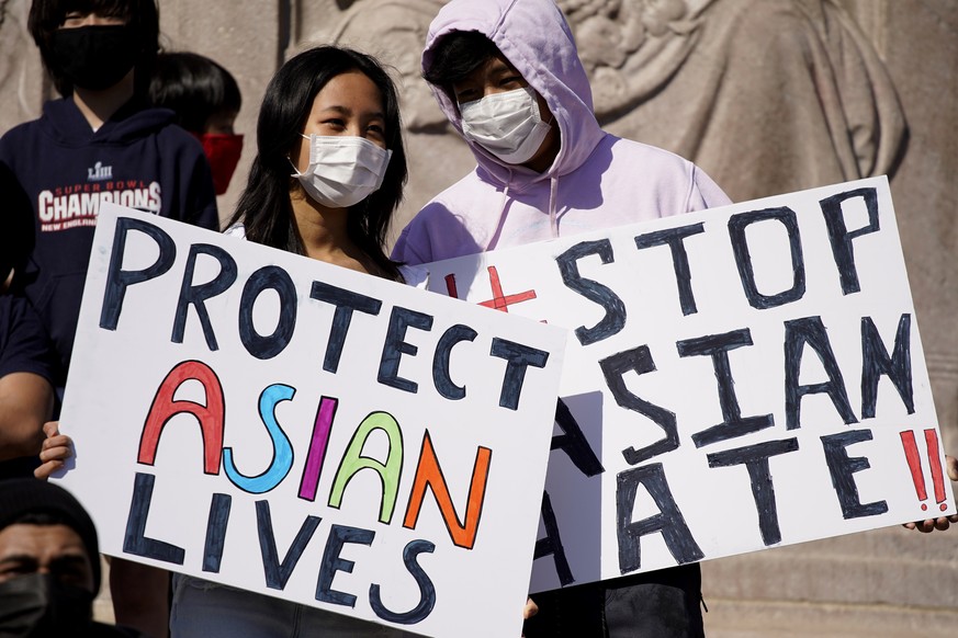 FILE - This March 20, 2021, file photo shows people holding signs as they attend a rally to support Stop Asian Hate at the Logan Square Monument in Chicago. A national coalition of civil rights groups ...