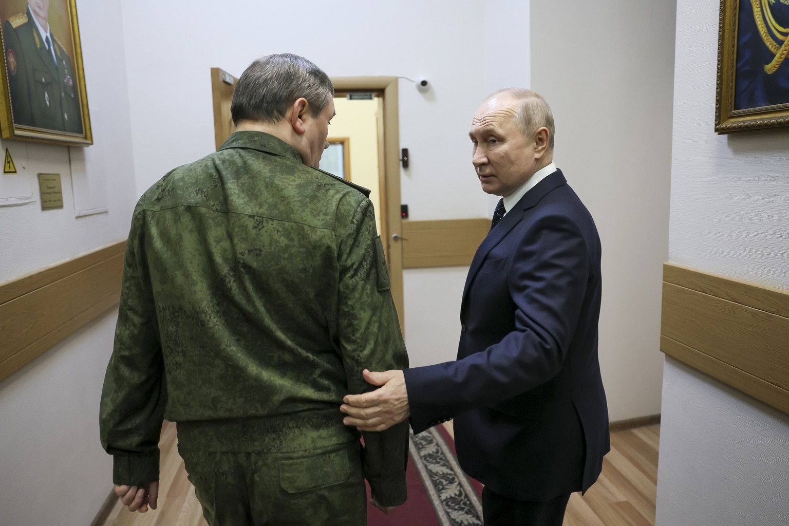 Russian President Vladimir Putin, right, and Russian Chief of General Staff Valery Gerasimov talk to each other as they walk down the corridor at the headquarters of Russia&#039;s Southern Military Di ...