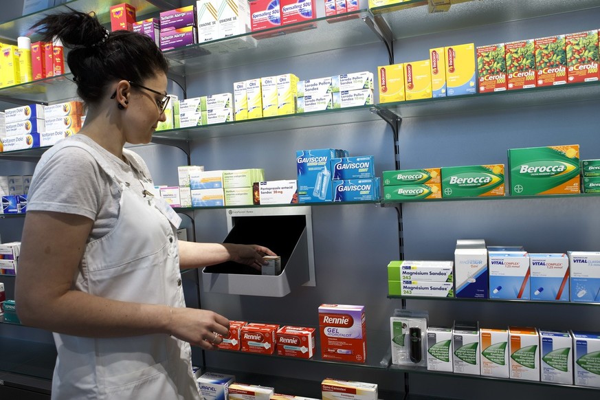 Une assistante en pharmacie de Pharma24, situee dans le batiment des HUG, prend une boite de medicament a l&#039;une des sortie du robot distributeur de medicament, ce mardi 25 avril 2017 a Geneve. La ...