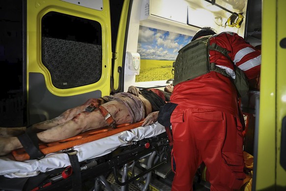 In this photo provided by Kharkiv City Administration, an ambulance evacuates an injured man after a multi-storey apartment building was hit by Russian attack in Kharkiv, Ukraine, late Wednesday, Oct. ...