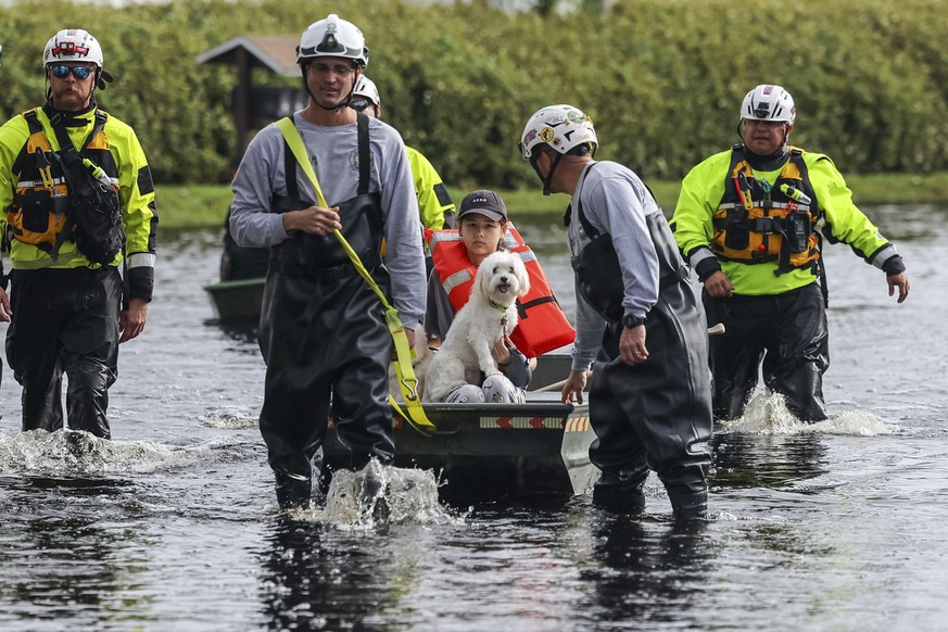 Amy Bishop is evacuated from her home by Pasco County Fire and Rescue and Sheriff&#039;s Office teams as waters rise in her neighborhood after Hurricane Milton caused the Anclote River to flood, Frida ...